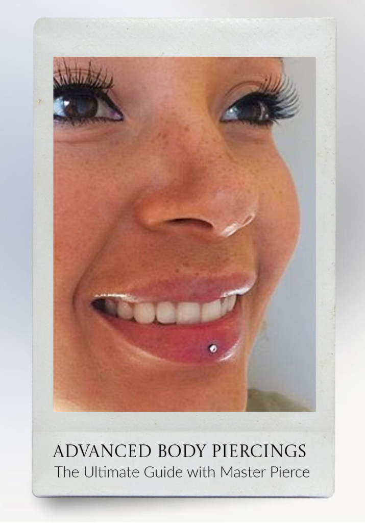 A close-up of a smiling person with a labret piercing below their bottom lip, featured on a book cover titled Advanced Body Piercings: The Ultimate Guide with Master Pierce..