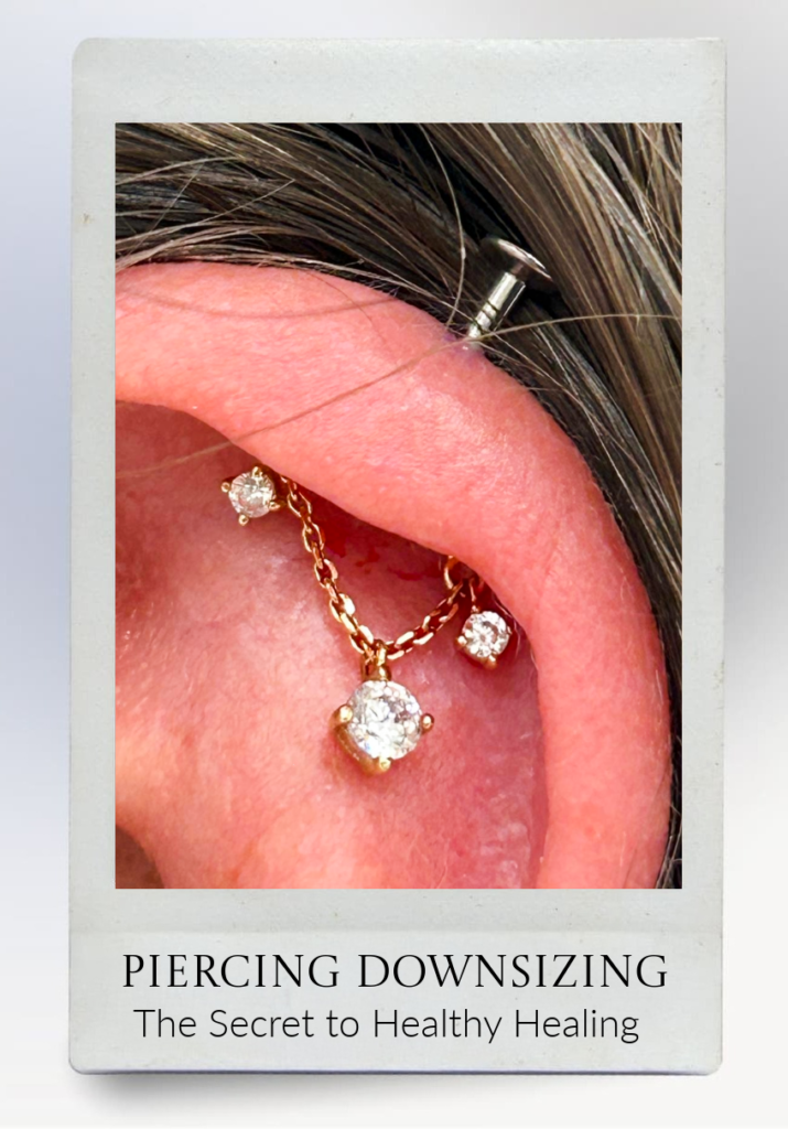 A close-up of an ear with three gold and diamond piercings, one connected by a chain. Text below reads: Piercing Downsizing: The Secret to Healthy Healing..