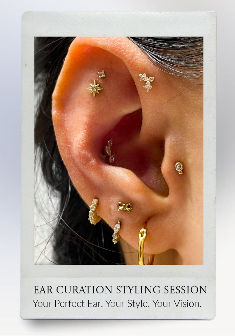 A close-up of an ear with multiple gold and diamond earrings in different shapes, including a star, cross, hoop, and bow, displayed on a promotional card for an ear curation styling session.